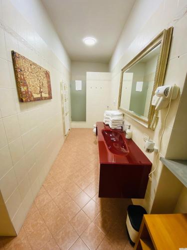 a bathroom with a red sink and a mirror at La Casa di Amici Miei in Cremona