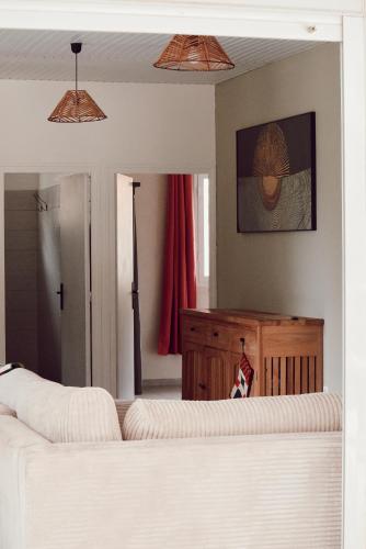 a living room with a white couch and a mirror at Villa Massy in Rivière-Salée