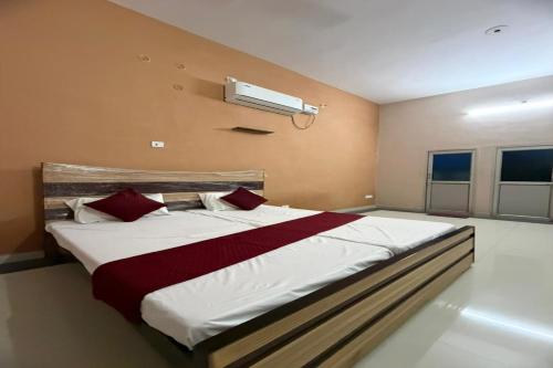 a bedroom with a large bed with red pillows at Divine Blessings Banquet and Hotel in Prayagraj