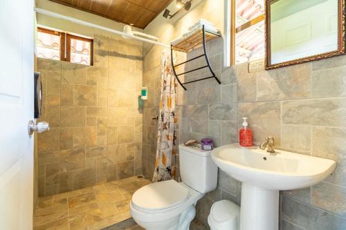 a bathroom with a toilet and a sink at Cabañas Retiro Del Rio in Guayabal