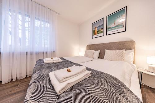 una camera da letto con un letto con asciugamani sopra di The R Apartment Farnsberg a Basilea