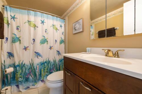 a bathroom with a sink and a toilet and a shower curtain at Maalaea Kai Resort 213 in Wailuku