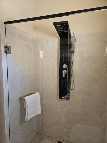 a shower in a bathroom with a glass door at Sunset Senegal in Rufisque