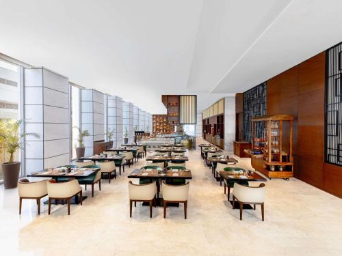 a large dining room with tables and chairs at Novotel Jaipur Convention Centre in Jaipur
