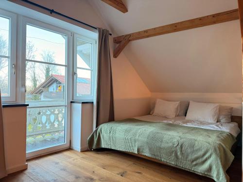 a bedroom with a bed and a large window at Loft am Wappach in Bayerisch Gmain