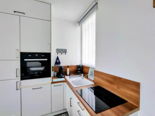 een keuken met witte kasten en een spoelbak bij escapade à Wimereux in Wimereux