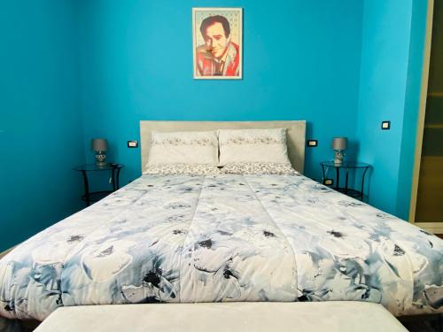 ein blaues Schlafzimmer mit einem Bett mit blauer Wand in der Unterkunft Amici Miei Rooms in Cremona