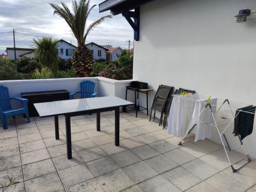a white table and chairs on a patio with a table at Appartement avec Terrasse à Beaurivage in Biarritz