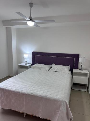 a bedroom with a large bed with a purple headboard at Depto centro in Villa Carlos Paz