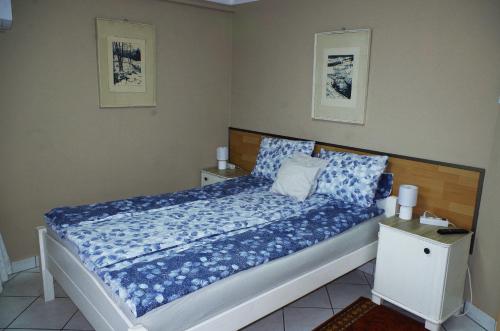 a bedroom with a bed with blue sheets and pillows at Heppház in Harkány