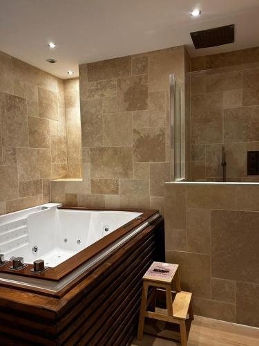 een grote badkamer met een badkuip en een toilet. bij Bella Notte Spa in Dijon