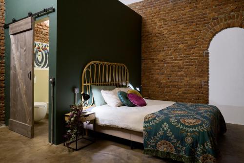 a bedroom with a bed and a brick wall at La SERAFINA in Vanzaghello