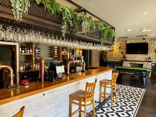 een bar met twee stoelen en een pooltafel bij Radstock Hotel near Bath in Radstock