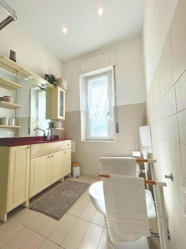 a bathroom with a toilet and a sink and a window at Duca - Gorizia City Apartment - 80 smq Central in Gorizia