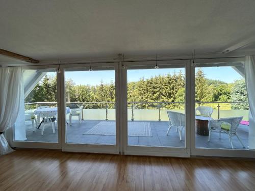 een woonkamer met glazen schuifdeuren en een patio bij Ferienwohnung Schmalental in Barntrup