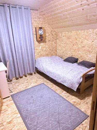 a bedroom with a bed and a blue rug at Alexandra Forest Lake House in Konsu