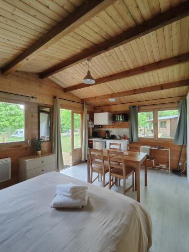 a bedroom with a large bed and a kitchen at Camping Les Rochelles in Prunay-Cassereau