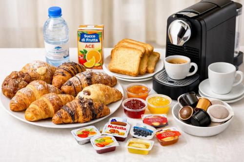 a table with a plate of breakfast foods and a coffee maker at South Blue Apartment in Trani
