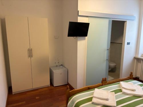 een slaapkamer met een bed en een tv aan de muur bij Affittacamere Penasa in Rabbi