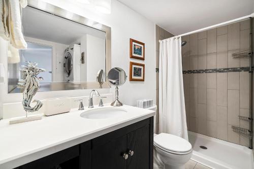 a bathroom with a sink and a toilet and a mirror at Kona Mansions#301 in Kailua-Kona