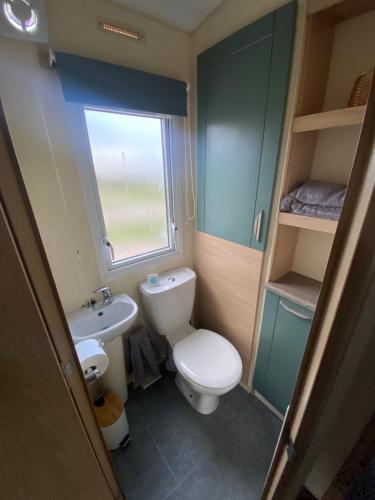 a small bathroom with a toilet and a sink at No 56 Headiton Caravan Park in Banff