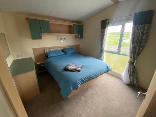 a small bedroom with a bed and a window at No 56 Headiton Caravan Park in Banff