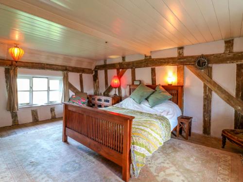 a bedroom with a bed in a room with beams at Town Farm in Eye