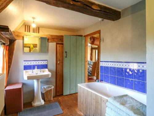 a bathroom with a tub and a sink at Town Farm in Eye