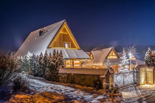een huis in de sneeuw 's nachts bij Luxury Chalet Wioska Jagny in Poronin