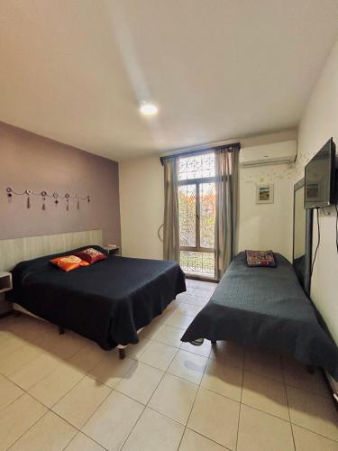 a bedroom with two beds and a tv and a window at Espacio Planetaria in Córdoba