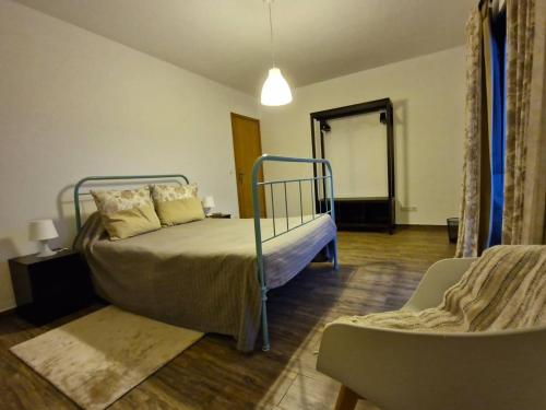 a bedroom with a bed and a couch and a chair at Estrela do Frade in Maia