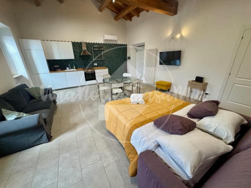 un soggiorno con due letti e un divano di L' Attico "UnaNotteaCasaMia" a Sacrofano