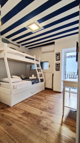 a bedroom with a bunk bed with a blue and white ceiling at Luxury House in Cefalù