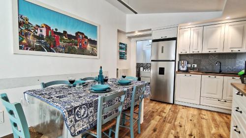 una cucina con tavolo con sedie e frigorifero di Luxury House a Cefalù