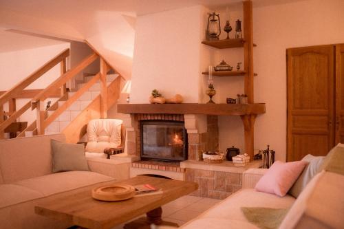 een woonkamer met een open haard en een trap bij La Ferme du Veyre in Saint-Bonnet-en-Champsaur