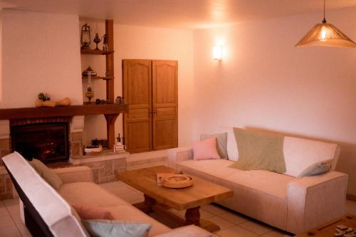 een woonkamer met een bank en een tafel bij La Ferme du Veyre in Saint-Bonnet-en-Champsaur