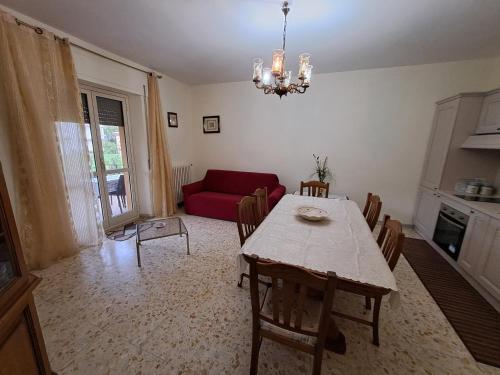 a living room with a table and a red couch at Casa di Biagio e Maria in Trecchina