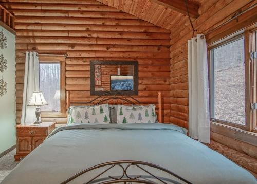 a bedroom with a bed in a log cabin at 2 Br Plus Loft: Hawthorne Valley 4 in Snowshoe