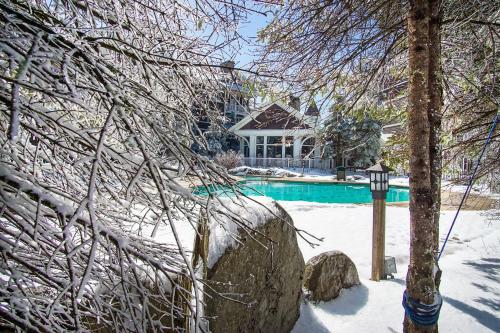 a house with a swimming pool covered in snow at Allegheny Springs 414: Junior Studio Slopeside in Snowshoe