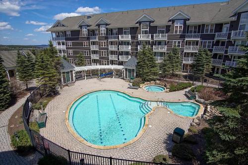 a large apartment building with a large swimming pool at Allegheny Springs 414: Junior Studio Slopeside in Snowshoe