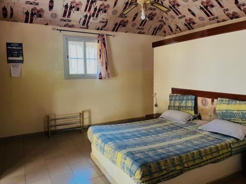 a bedroom with a bed and a ceiling at Kabacoto Lodges in Darou Rhamane