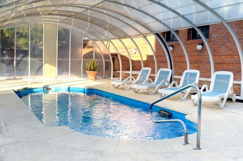 a swimming pool in a building with chairs around it at Salto Grande Hotel in Punta del Este