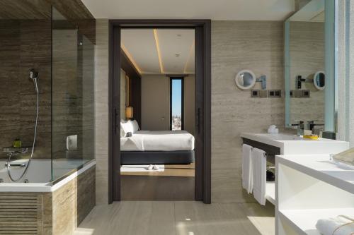 een badkamer met een bed, een bad en een wastafel bij VP Plaza España Design in Madrid
