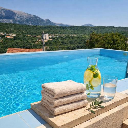 a table with towels and a glass of water next to a swimming pool at Villa Sea La Vie in Utjeha