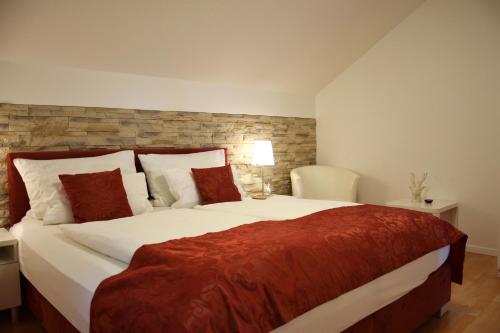 阿特湖畔翁特拉赫洛茵德尔公寓酒店的卧室里有一张大床，上面铺着红毯子