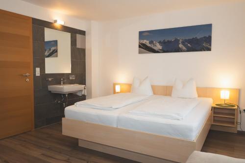 een slaapkamer met een bed, een wastafel en een spiegel bij Möslehof in Kauns