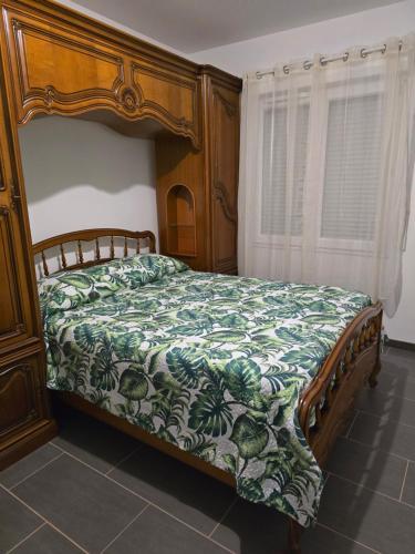 una camera con un letto con copriletto verde e bianco di Logement entier a Montech