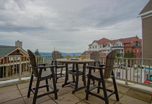 a table and chairs on a balcony with a view at Highland House #102-104: 2Br: 2 Bath in Snowshoe