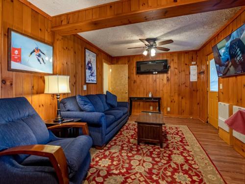 a living room with blue couches and a flat screen tv at Stemwinder 6B 1 Bedroom, 1 Full Bath, Slope Side in Slaty Fork
