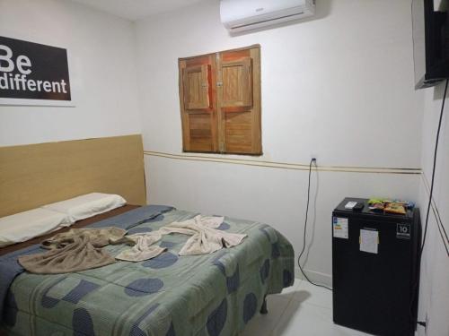 una camera con letto e piccolo frigorifero di Pousada dos Artistas a Japaratinga